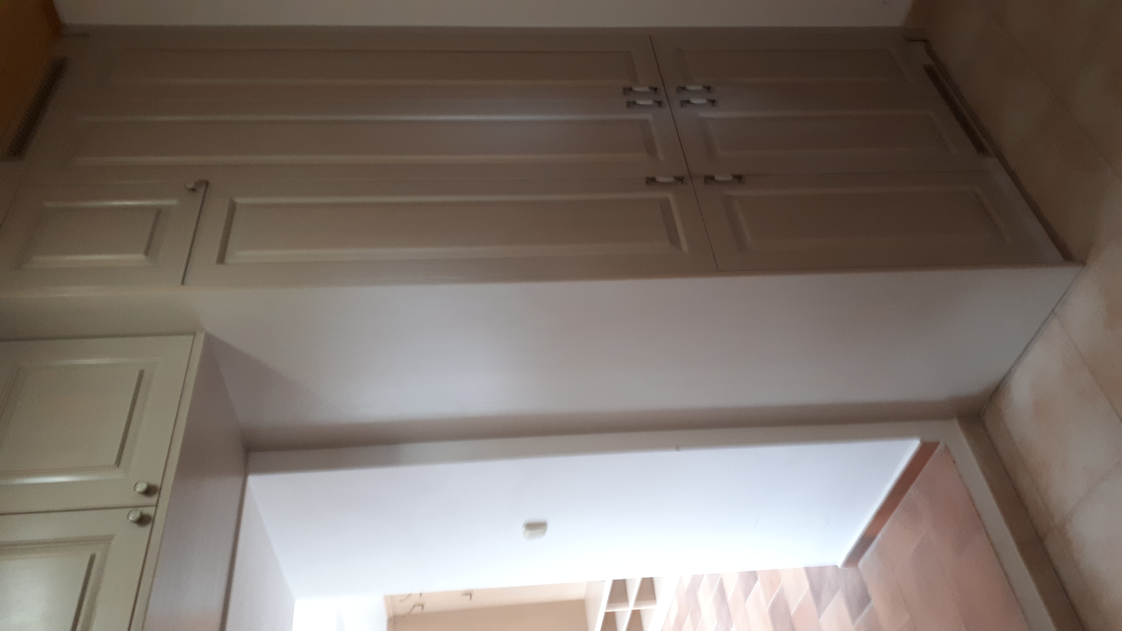 Vestavěná šedá skříň s horními skříňkami nad průchodem