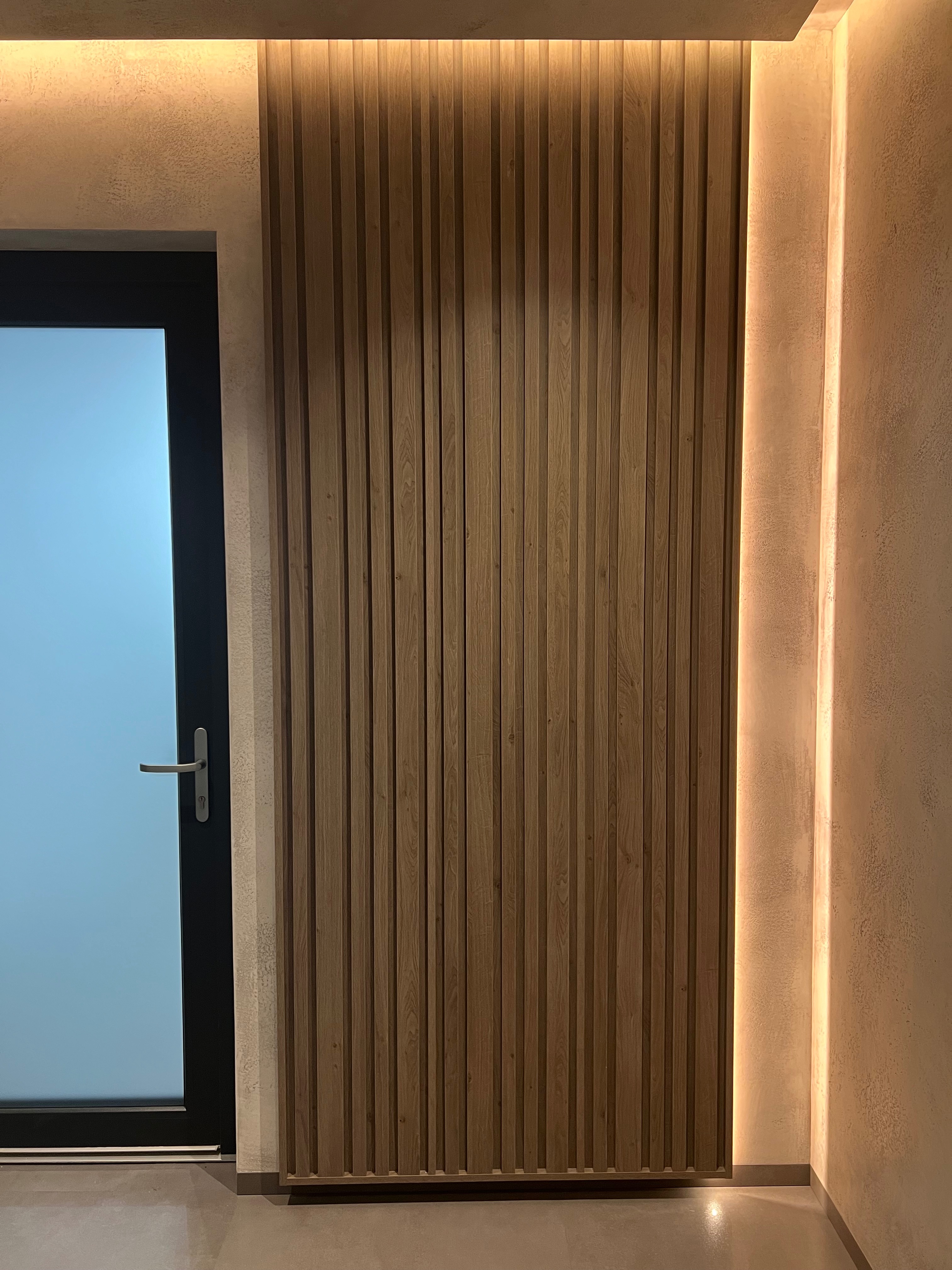 Dubový lamelový panel s LED podsvícením vedle prosklených dveří