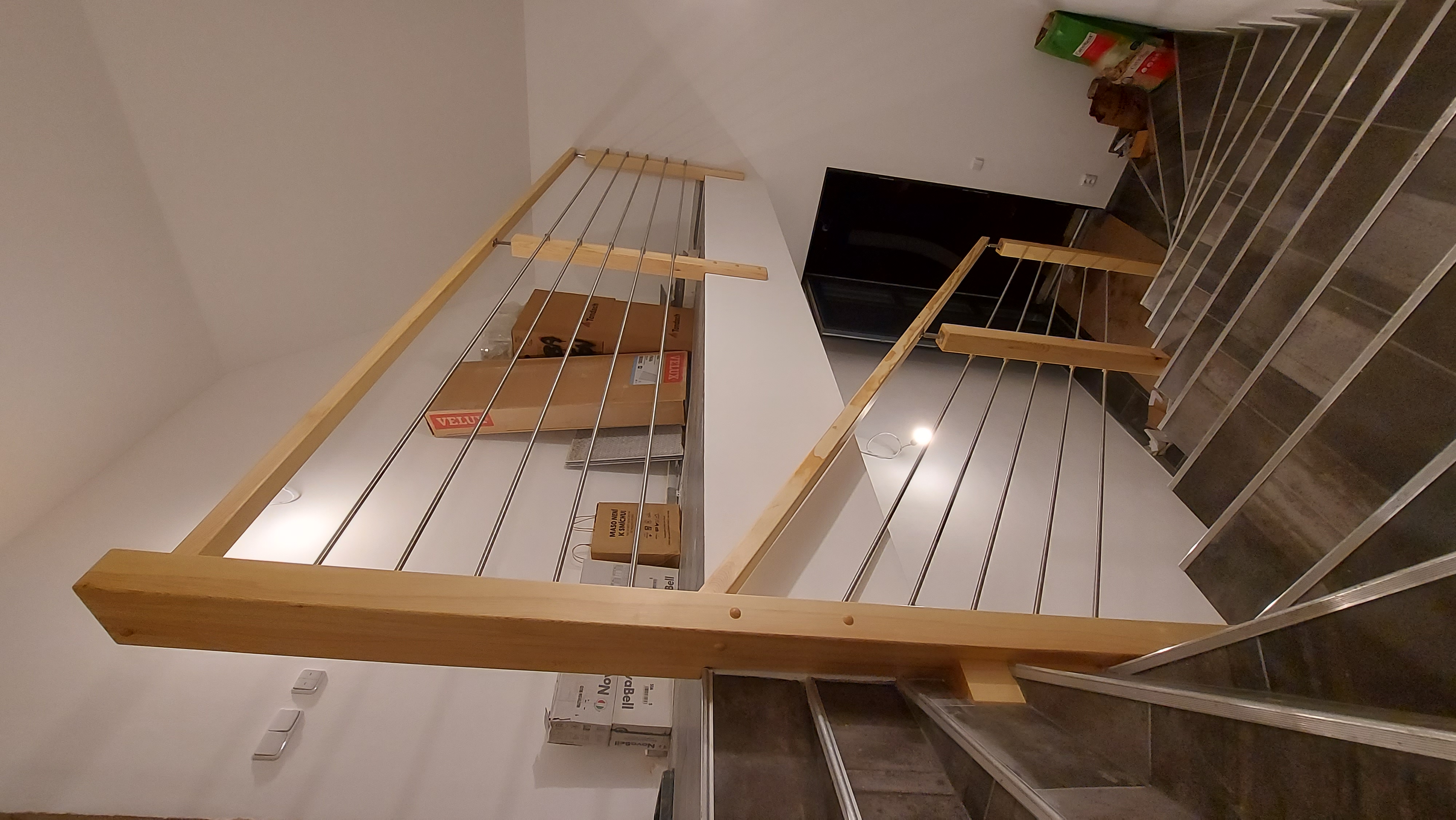 Zábradlí s dřevěnými sloupky a nerezovými tyčemi na galerii
