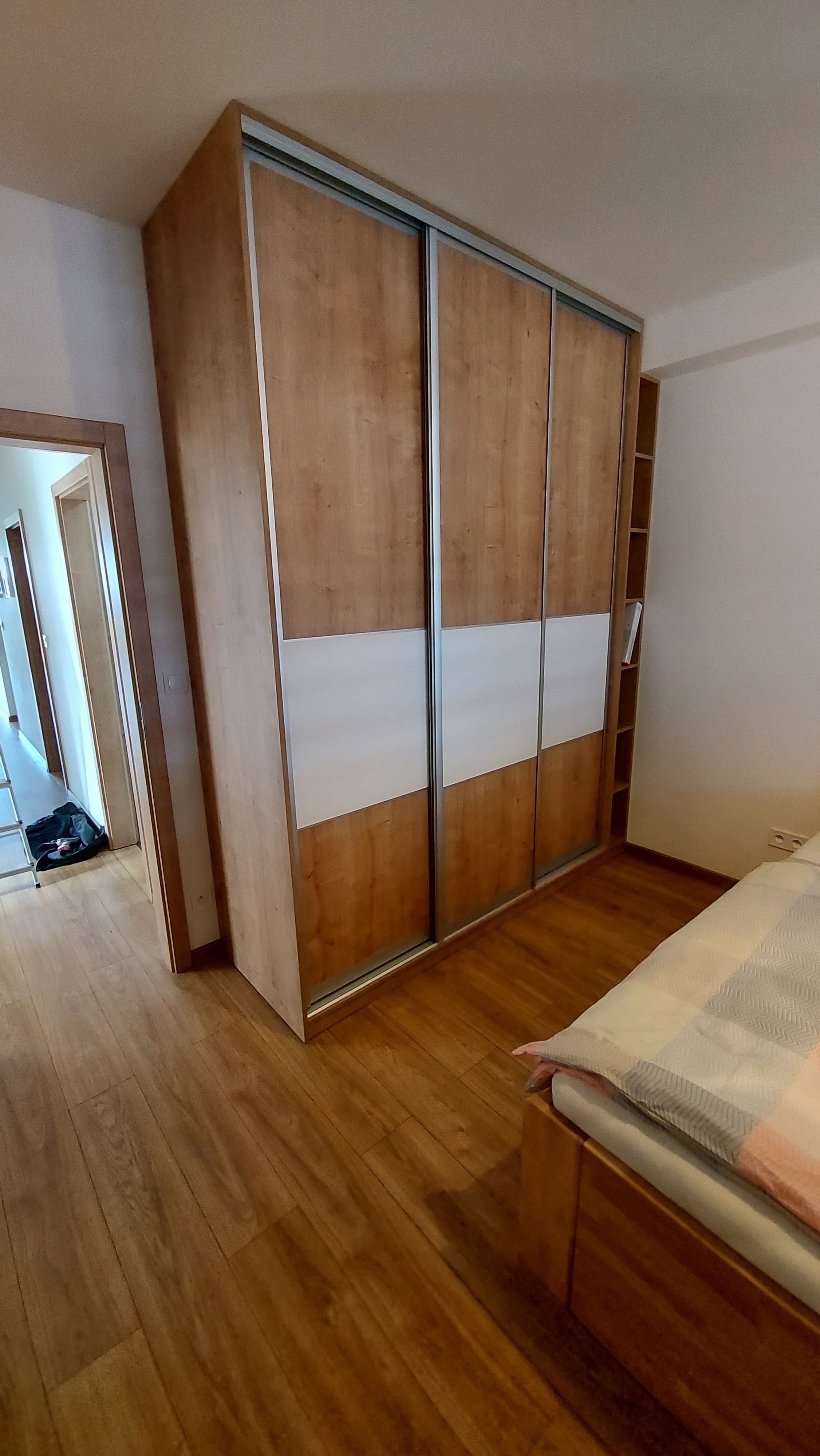 Skříň s posuvnými dveřmi v dekoru dubu s bílým pásem a postranními policemi